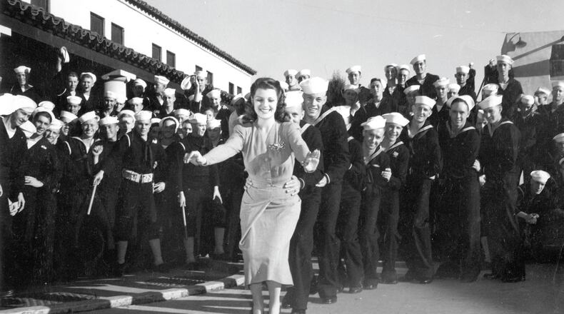 Rita Hayworth leads a line of sailors in the bunny hop at a USO show; Courtesy of Turner Classic Movies