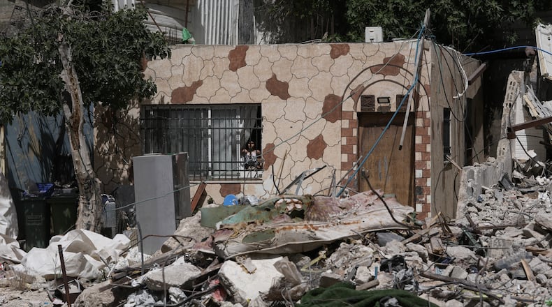 A Palestinian girl looks out a window at the rubble of a home demolished by Israeli authorities in the Silwan neighborhood of east Jerusalem, May 19, 2026. (AP Photo/Mahmoud Illean)