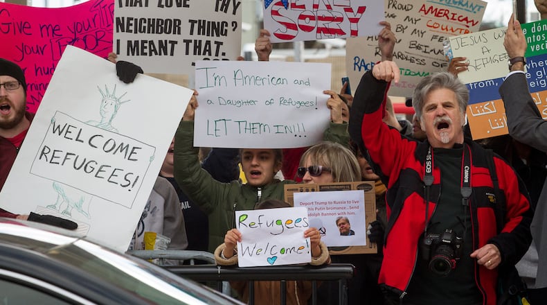 Protesters hold up signs during a demonstration against President Trump's recent travel ban Sunday at Hartsfield-Jackson Atlanta International Airport January 30, 2017. STEVE SCHAEFER / SPECIAL TO THE AJC