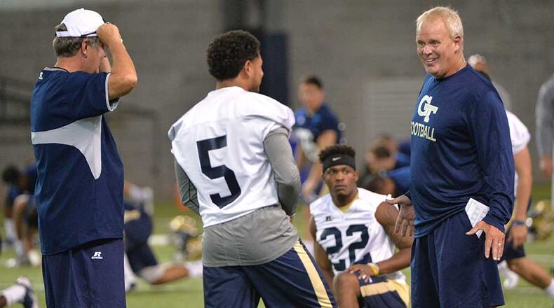 Assistant Andy McCollum talks with quarterback Justin Thomas as coach Paul Johnson looks on.