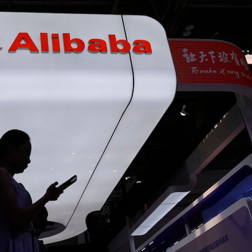 FILE - A visitor walks in front of Alibaba booth during the 3rd China International Supply Chain Expo at the China International Exhibition Center, in Beijing, China, Friday, July 18, 2025. (AP Photo/Mahesh Kumar A., File)