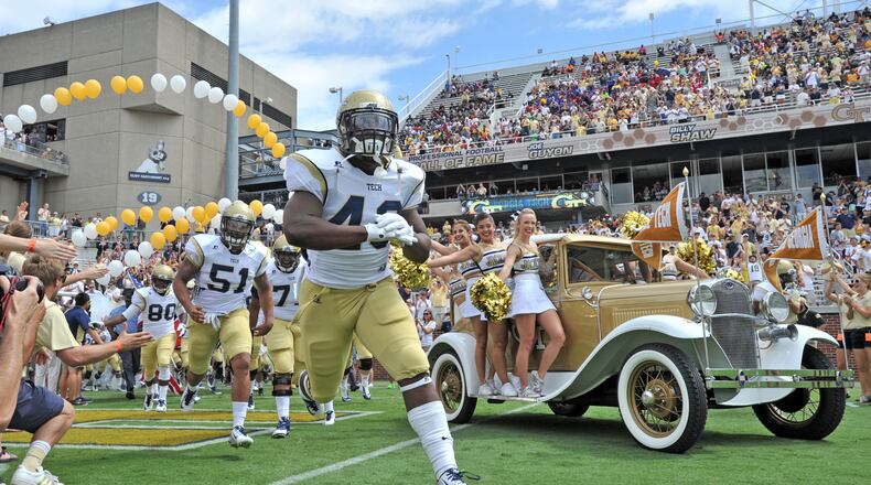 Georgia Tech’s Ramblin Wreck and cheerleaders lead the football team onto the field to start the before the start of the Georgia Tech season opener against the Wofford Terriers at Bobby Dodd Stadium on Saturday, August 30, 2014. HYOSUB SHIN / HSHIN@AJC.COM