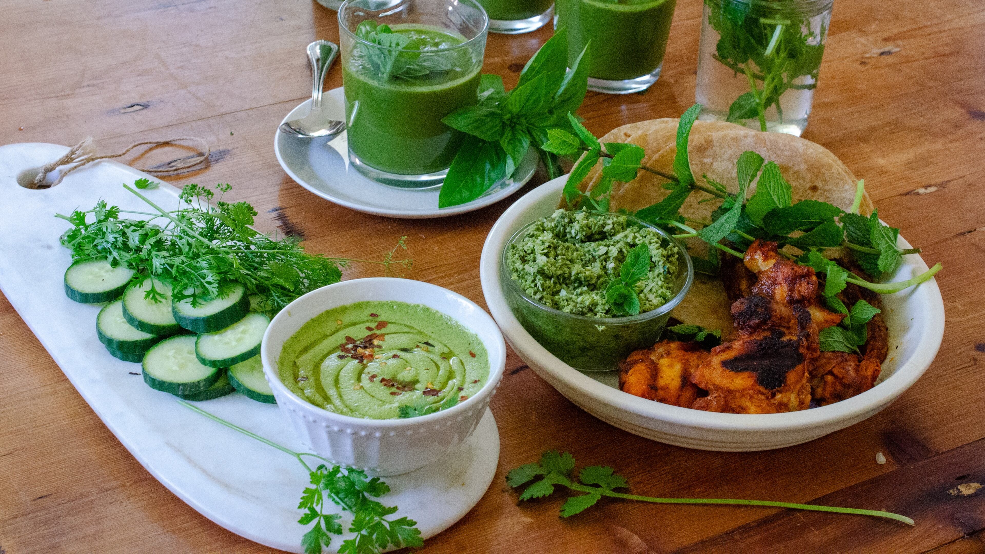 Fresh summer herbs are the essential ingredients in (clockwise from top) Chilled Basil Zucchini Soup, Indian Green Chutney with Tandoori Chicken and Zhoug with Cucumbers. (Virginia Willis for the AJC)