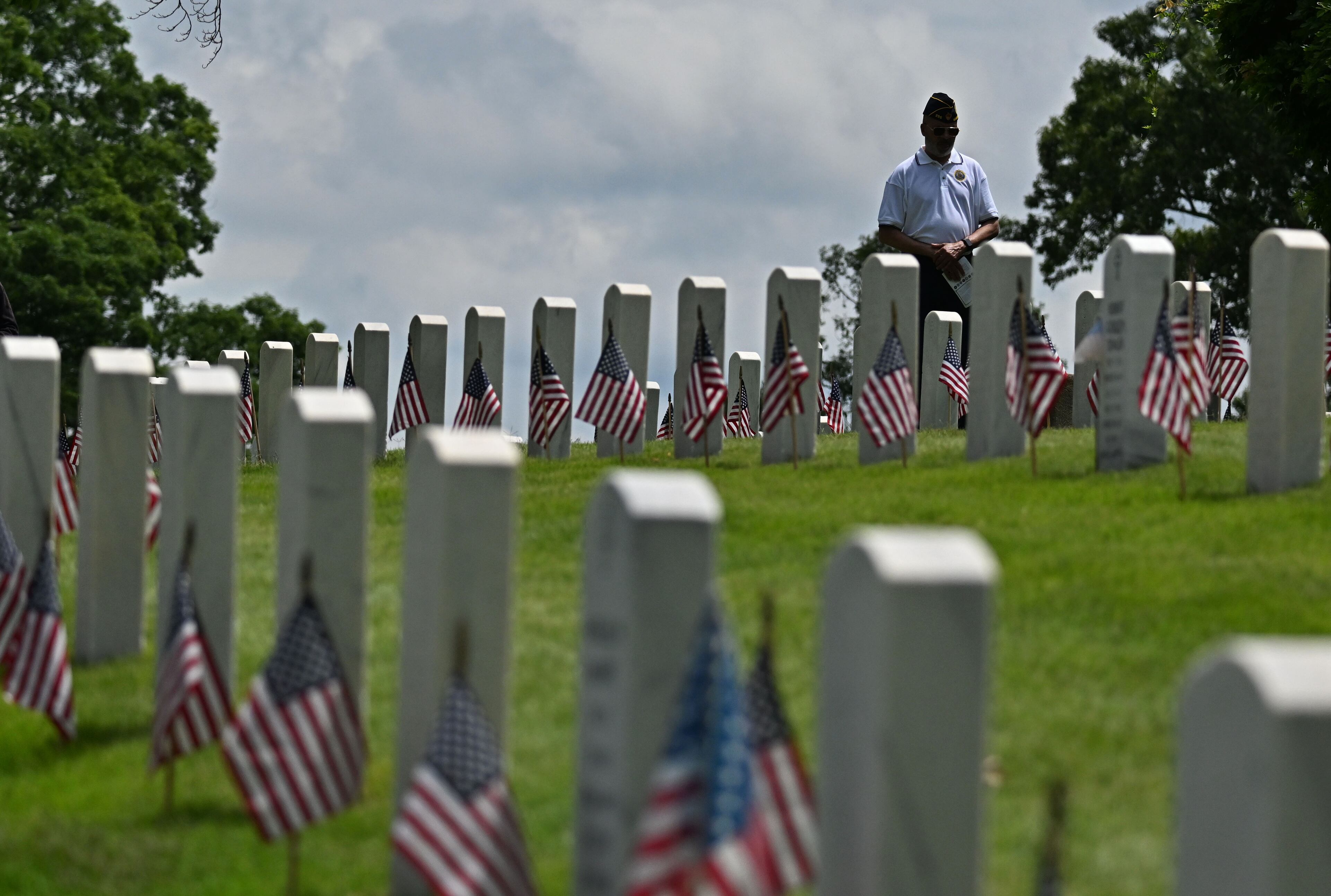 An attendant pays his respect during the Memorial Day ceremony at Marietta National Cemetery, Monday, May 26, 2025, in Marietta. (Hyosub Shin / AJC)