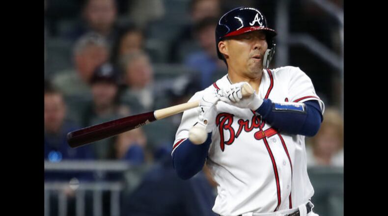 Atlanta Braves' Kurt Suzuki is hit by a pitch on his right wrist in the fourth inning of a baseball game against the Philadelphia Phillies, Friday, March 30, 2018, in Atlanta. (AP Photo/Todd Kirkland)