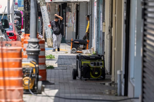 Generators line the sidewalk of a commercial street in Barrio Obrero as shops try to remain open during a prolonged power outage in San Juan, Puerto Rico, Thursday, April 17, 2025. (AP Photo/Alejandro Granadillo)
