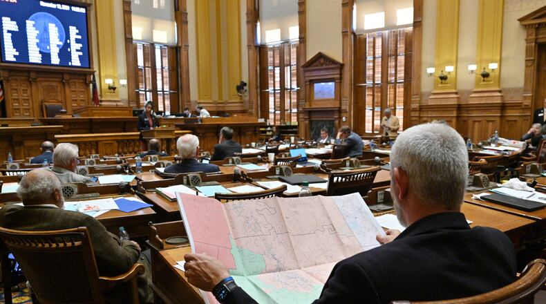 November 19, 2021 Atlanta - Chuck Payne (R-Dalton), foreground, looks at a map as Nikki Merritt (D-Grayson), background, speaks in opposition of SB 2 EX, newly-drawn congressional maps, in the Senate Chambers during a special session at the Georgia State Capitol in Atlanta on Friday, November 19, 2021. (Hyosub Shin / Hyosub.Shin@ajc.com)