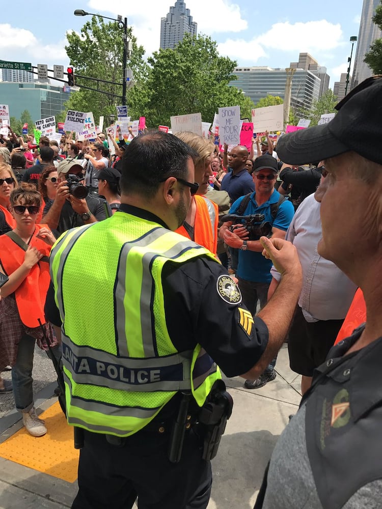 Police talking with Trump protesters ahead of the president's speech at the NRA convention