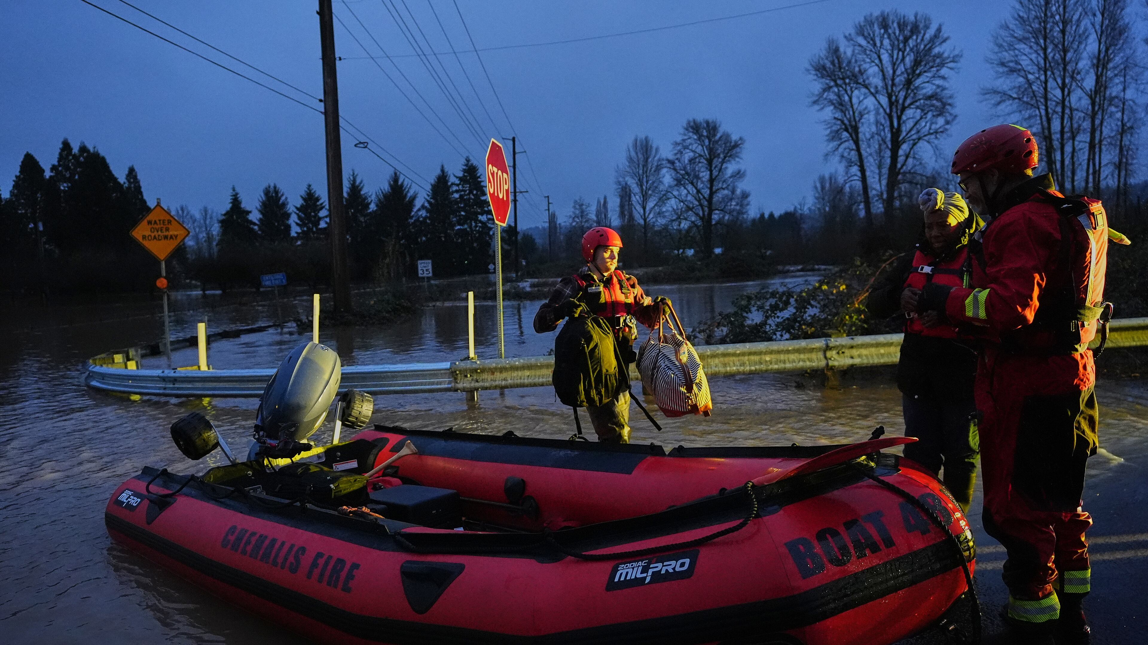 Chehalis Fire rescue workers help residents evacuate their flooded neighborhood after heavy rains in the region Tuesday, Dec. 9, 2025, in Chehalis, Wash. (AP Photo/Lindsey Wasson)