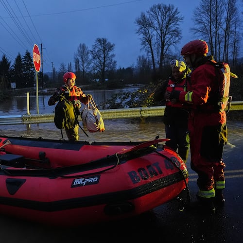 Chehalis Fire rescue workers help residents evacuate their flooded neighborhood after heavy rains in the region Tuesday, Dec. 9, 2025, in Chehalis, Wash. (AP Photo/Lindsey Wasson)