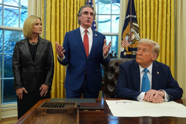 FILE - Interior Secretary Doug Burgum speaks as his wife, Kathryn, and President Donald Trump listen, in the Oval Office of the White House, Friday, Jan. 31, 2025, in Washington. (AP Photo/Evan Vucci,File)