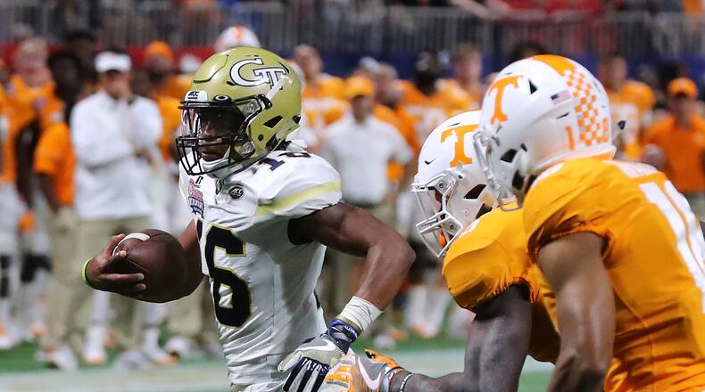 Georgia Tech quarterback TaQuon Marshall runs past Tennessee defenders for a first down on a scoring drive that ended with a touchdown during the second quarter in a NCAA college football game on Monday, Sept. 4, 2017, in Atlanta. (Curtis Compton/Atlanta Journal-Constitution via AP)