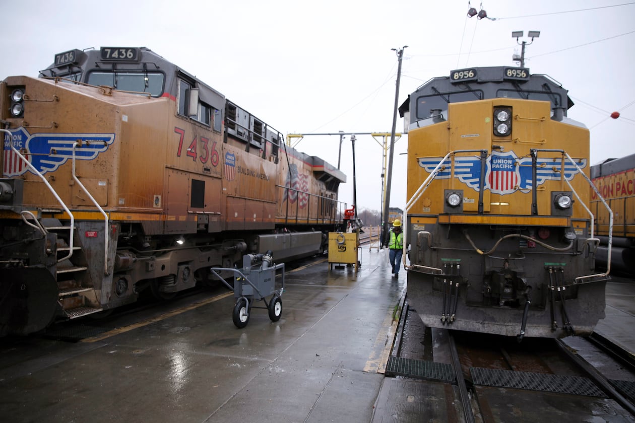 FILE - A Union Pacific worker walks between two locomotives that are being serviced in a railyard in Council Bluffs, Iowa, on Dec. 15, 2023. (AP Photo/Josh Funk, File)