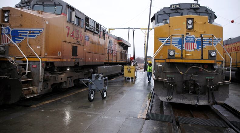 FILE - A Union Pacific worker walks between two locomotives that are being serviced in a railyard in Council Bluffs, Iowa, on Dec. 15, 2023. (AP Photo/Josh Funk, File)