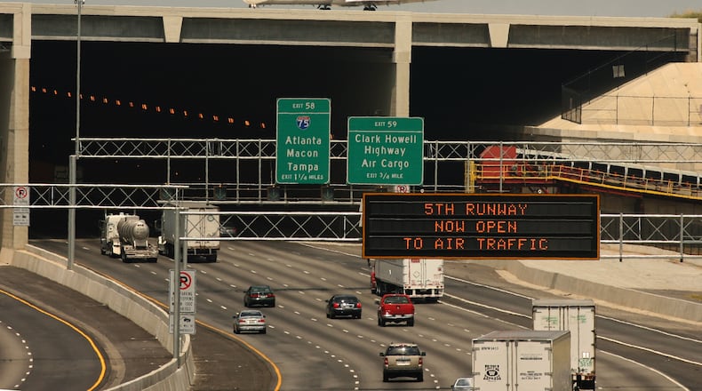 060527 - RIVERDALE, GA: A Delta plane rolls over the 5th runway bridge as cars continue to move on Interstate 285 on Saturday, 5/27/06. Today was the first day of runway was open to air traffic .PHOTO BY JOHNNY CRAWFORD/AJC STAFF