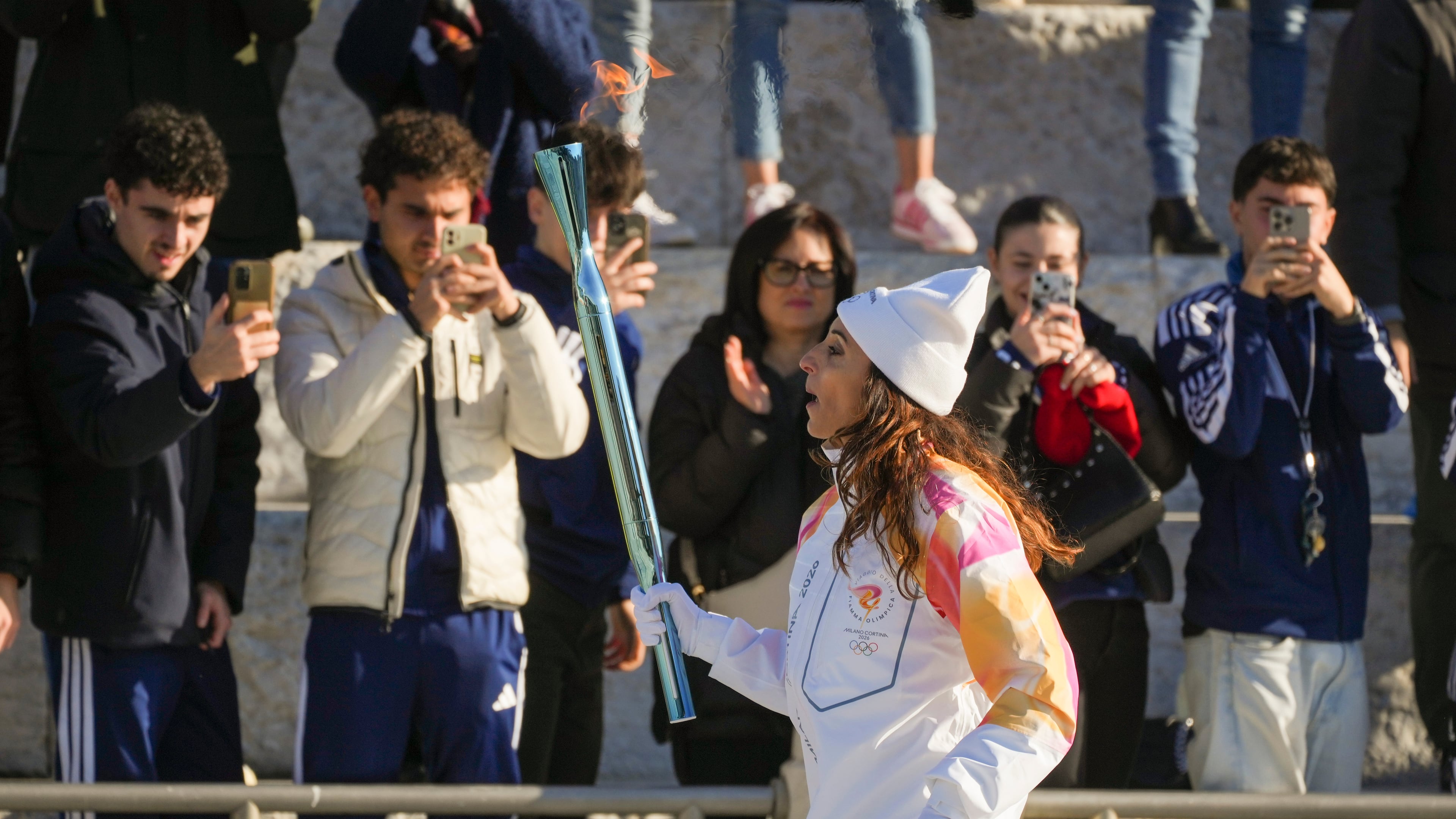 Italian former foil fencer and Olympic and world champion Elisa Di Francisca carries the 2026 Milan Cortina Winter Olympics torch in Rome as it begins its journey through Italy, Saturday, Dec. 6, 2025, a journey that will conclude in Milan in February 2026. (AP Photo/Andrew Medichini)