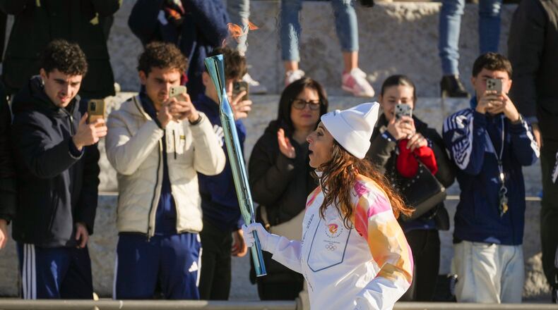 Italian former foil fencer and Olympic and world champion Elisa Di Francisca carries the 2026 Milan Cortina Winter Olympics torch in Rome as it begins its journey through Italy, Saturday, Dec. 6, 2025, a journey that will conclude in Milan in February 2026. (AP Photo/Andrew Medichini)