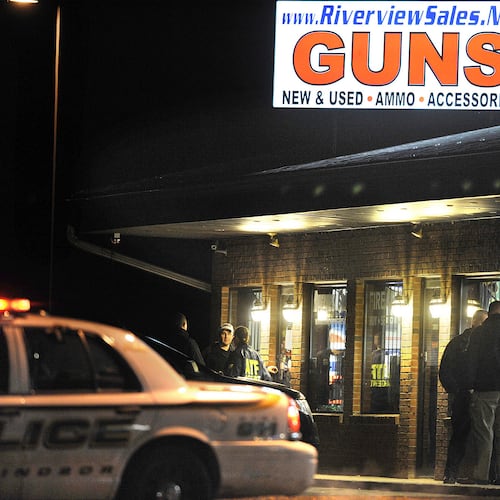 FILE - In this Dec. 20, 2012 file photo, law enforcement officials stand outside Riverview Gun Sales, as authorities raid the store in East Windsor, Conn. (AP Photo/Jessica Hill, File)