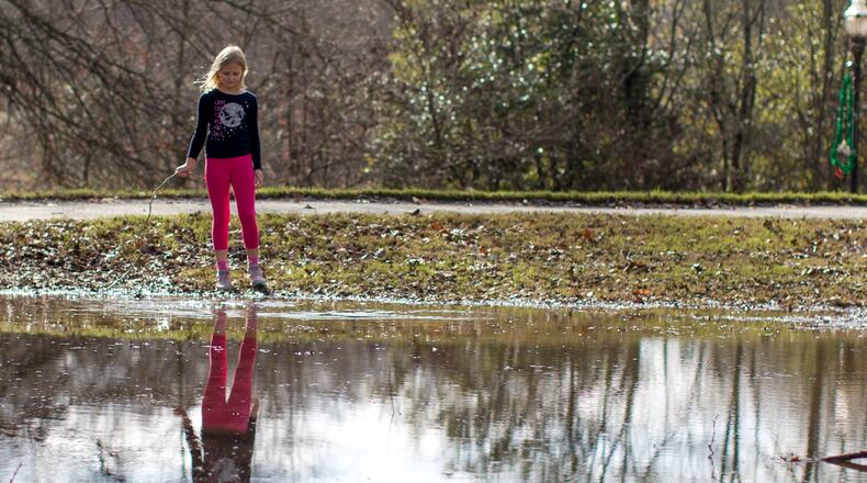 Teresa, 8, plays near a puddle of water in Piedmont Park on Tuesday, Dec. 29, 2015, in Atlanta. BRANDEN CAMP/SPECIAL