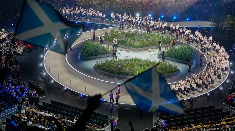 Scottish flags are waved by fans as the Scotland team arrives on stage during the Commonwealth Games opening ceremony in Glasgow, Scotland, Thursday, July 23, 2026. (AP Photo/Manish Swarup)