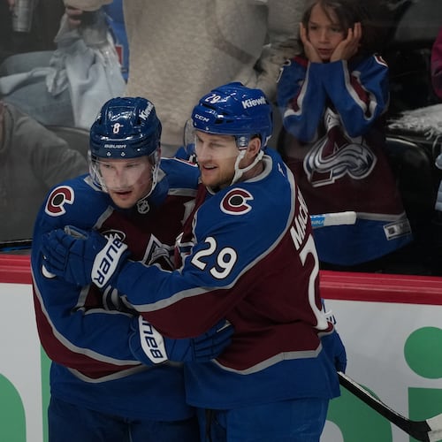 Colorado Avalanche defenseman Cale Makar, left, congratulates center Nathan MacKinnon after he scored a goal against the Minnesota Wild in the third period of Game 1 of an NHL hockey Stanley Cup second-round playoff series Sunday, May 3, 2026, in Denver. (AP Photo/David Zalubowski)