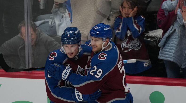 Colorado Avalanche defenseman Cale Makar, left, congratulates center Nathan MacKinnon after he scored a goal against the Minnesota Wild in the third period of Game 1 of an NHL hockey Stanley Cup second-round playoff series Sunday, May 3, 2026, in Denver. (AP Photo/David Zalubowski)