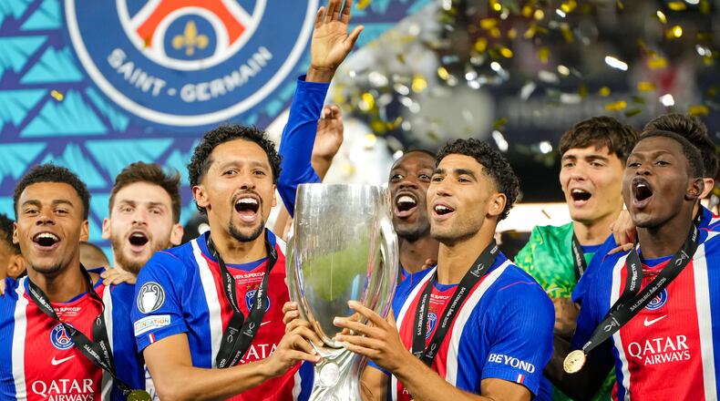 PSG's Marquinhos and PSG's Achraf Hakimi lift the trophy during celebrations at the end of the UEFA Super Cup soccer match between Paris Saint-Germain and Aston Villa in Salzburg, Austria, Wednesday, Aug.12, 2026. (AP Photo/Darko Bandic)