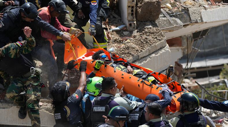 Rescue workers pull Moises Calzadilla, 11, from the rubble three days after earthquakes struck La Guaira, Venezuela, Saturday, June 27, 2026. (AP Photo/Fernando Vergara)
