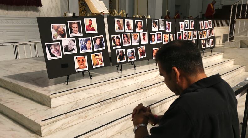 David Olson prays at the altar during an interfaith service. AJC photo: Curtis Compton