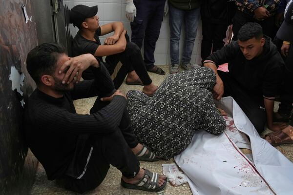 Relatives mourn next to the body of a Palestinian killed in an Israeli airstrike, at the morgue of Al-Aqsa Hospital in Deir al-Balah, central Gaza Strip, Saturday, April 12, 2025. (AP Photo/Abdel Kareem Hana)