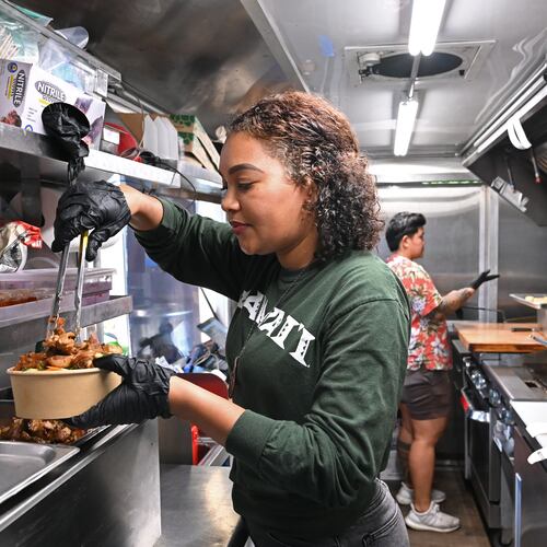 Jess Gorsuch (left) and Sara Siv, owners of Hapa Kitchen, prepare orders inside their food truck at Block & Drum in Chamblee on Wednesday, June 17, 2026. (Hyosub Shin/AJC)