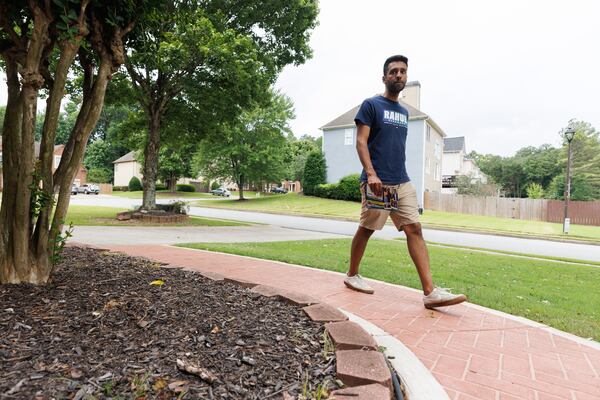 State Senate District 7 candidate Rahul Garabdu prepares to talk to voters in Peachtree Corners on Sunday. (Estela Muñoz/AJC)