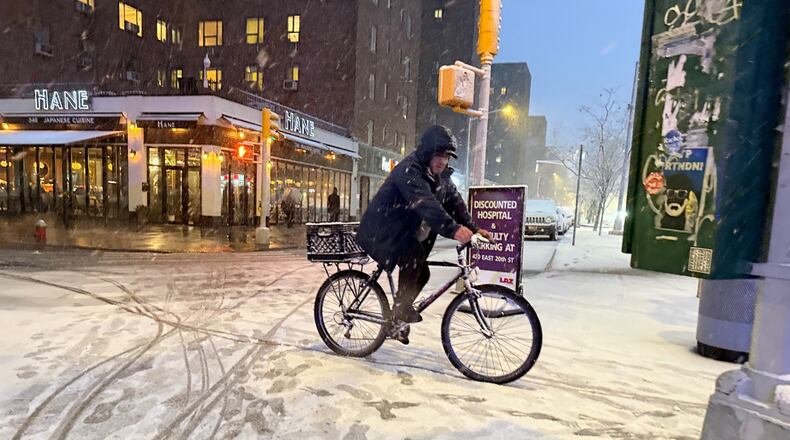 A man rides a bicycle in the beginning of an intense snowstorm by 20th Street and First Avenue, Sunday, Feb. 22, 2026, in New York. (AP Photo/Pamela Hassell)