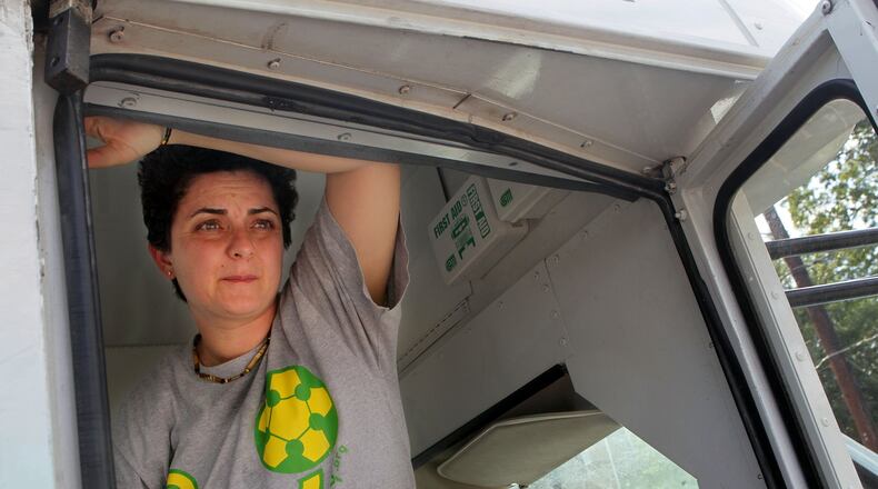 Luma Mufleh watches her students from inside the team bus before soccer practice in Clarkston in September 2012. AJC FILE PHOTO