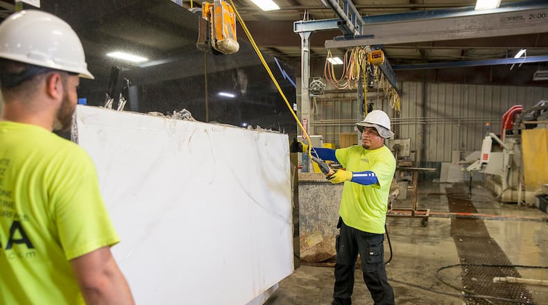 In this AJC file photo, workers handle a slab of quartz at a company in Newnan.