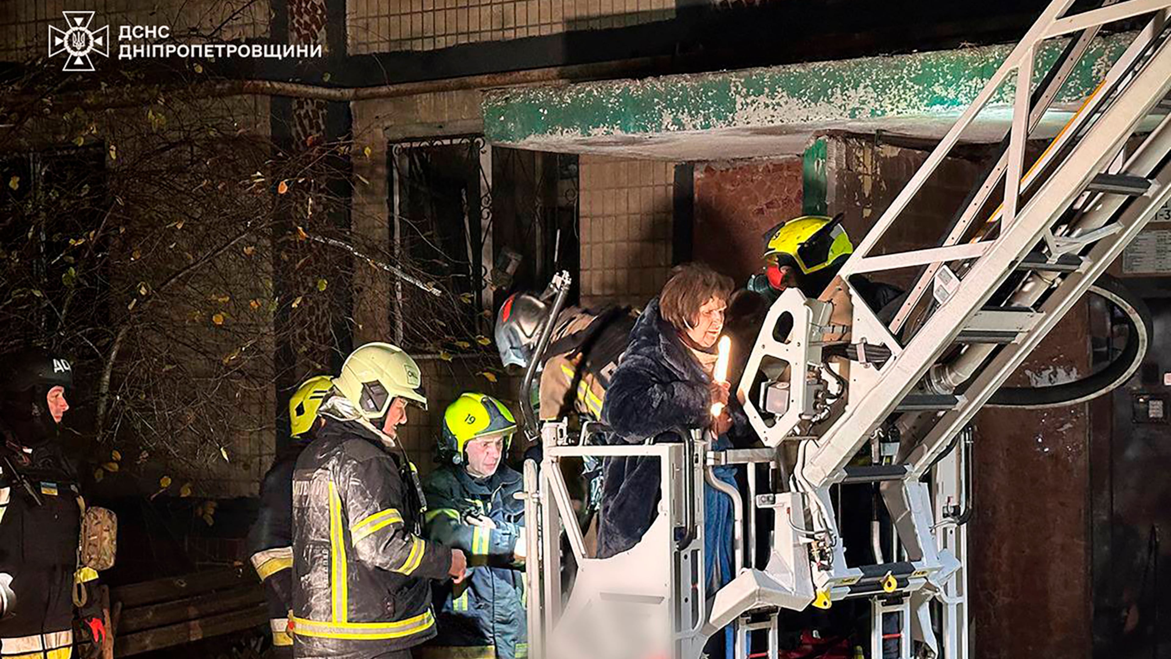 In this photo provided by the Ukrainian Emergency Service, firefighters evacuate a resident following a Russian rocket attack that hit a multi-storey apartment building in Dnipro, Ukraine, Saturday, Nov. 8, 2025. (Ukrainian Emergency Service via AP)