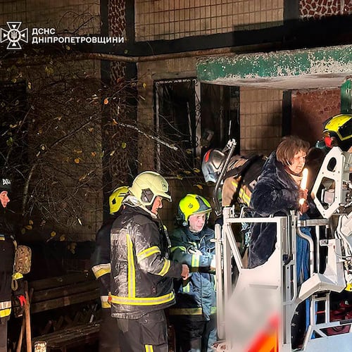 In this photo provided by the Ukrainian Emergency Service, firefighters evacuate a resident following a Russian rocket attack that hit a multi-storey apartment building in Dnipro, Ukraine, Saturday, Nov. 8, 2025. (Ukrainian Emergency Service via AP)