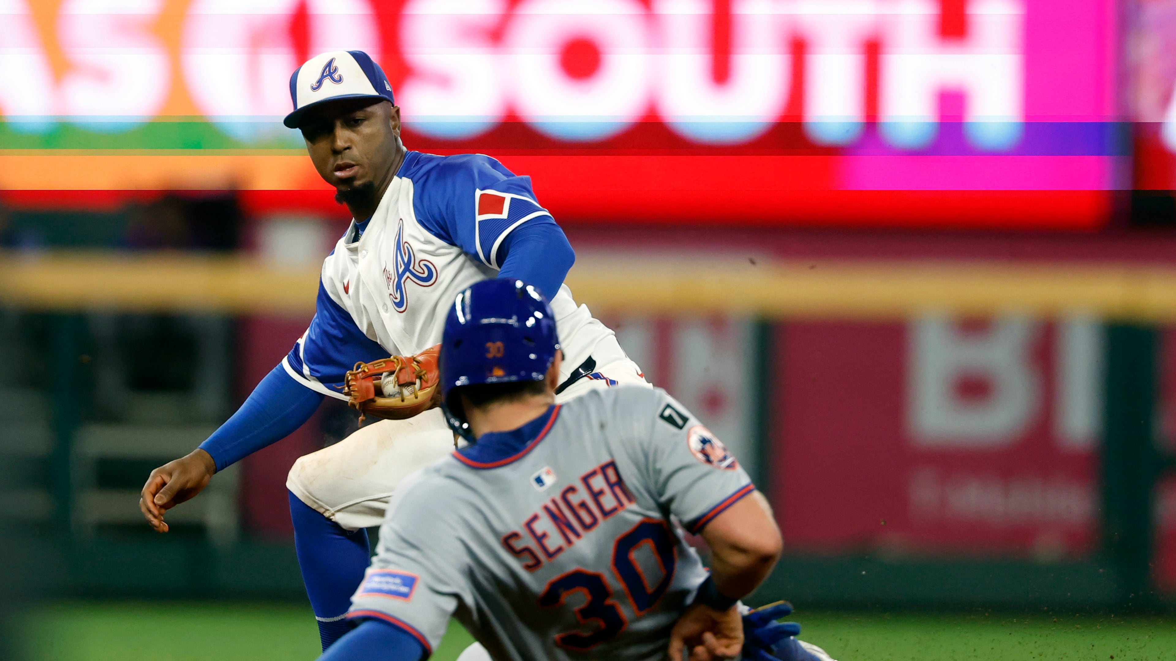 Atlanta Braves second baseman Ozzie Albies (1) gets the force out on New York Mets' Hayden Senger (30) as he slides into second base during the eighth inning of a baseball game, Saturday, Aug. 23, 2025, in Atlanta. (AP Photo/Butch Dill)