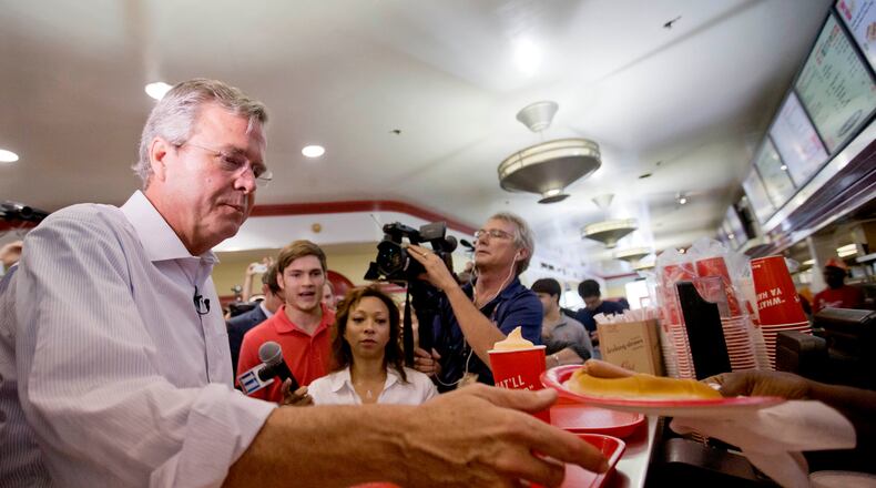 Republican presidential candidate, former Florida Gov. Jeb Bush, left, is handed a hot dog as he visits the Varsity restaurant in downtown Atlanta during a campaign stop on Tuesday. AP/David Goldman