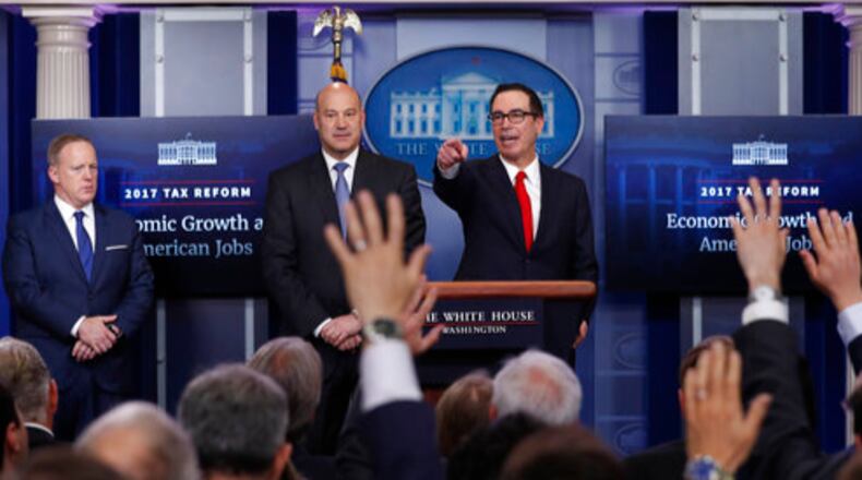 Treasury Secretary Steven Mnuchin, right, joined by National Economic Director Gary Cohn, center, and White House press secretary Sean Spicer speaks in the briefing room of the White House in Washington, Wednesday, April 26, 2017. President Donald Trump is proposing dramatically reducing the taxes paid by corporations big and small in an overhaul his administration says will spur economic growth and bring jobs and prosperity to the middle class. (AP Photo/Carolyn Kaster)
