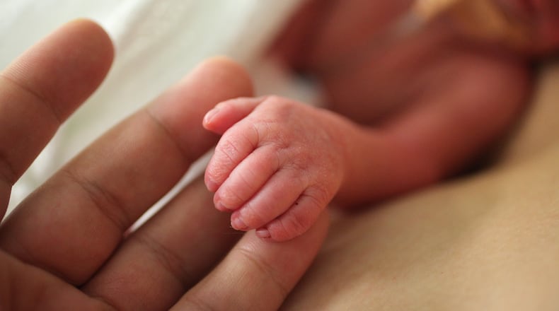 A premature newborn holds onto an adult's fingers. (Jennifer Polixenni Brankin/Getty Images)