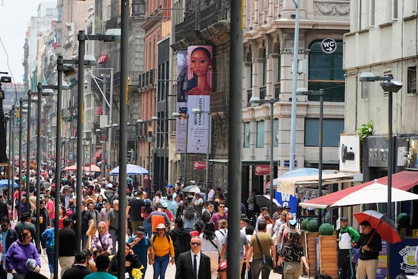 Pedestrians traverse Francisco I. Madero Avenue in downtown Mexico City, Thursday, July 10, 2025. (AP Photo/Fernando Llano)