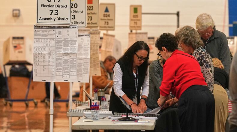 Workers prepare for voters at a poll site, in New York, Tuesday, Nov. 4, 2025. (AP Photo/Richard Drew)