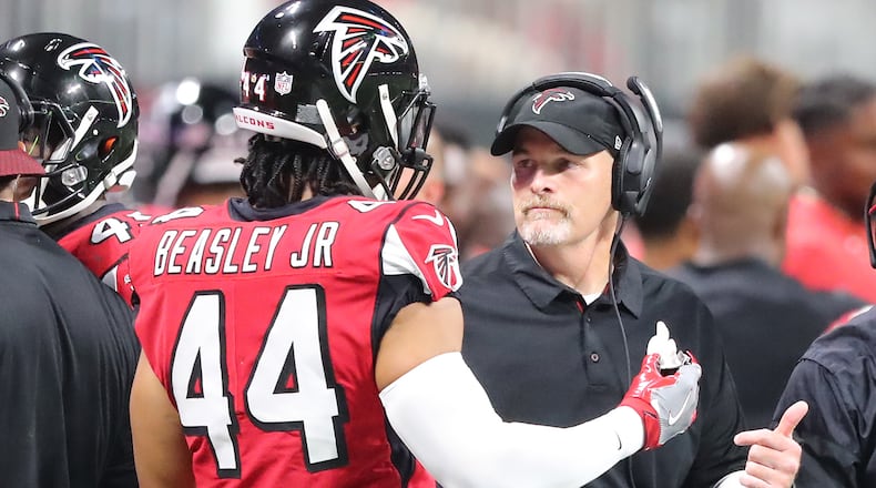 Falcons head coach Dan Quinn confers with Vic Beasley Jr. during the first half against the Green Bay Packers Sunday, Sept. 17, 2017, in Atlanta.