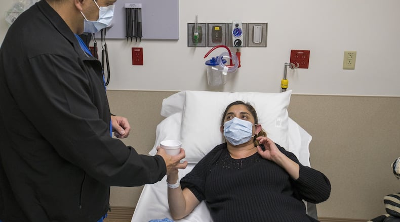 Joey Villalobos, RN, left, gives ibuprofen to a patient with the flu in the emergency room at St. Joseph’s Hospital in Orange, Calif., on Jan. 5, 2018. UC San Diego scientists have discovered a potential universal flu drug. (Allen J. Schaben/Los Angeles Times/TNS)