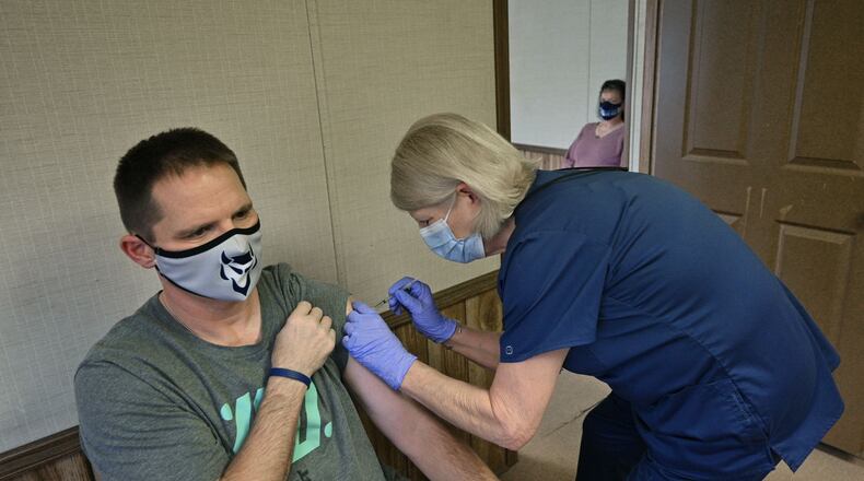 Elbert County High School teacher Richard Andrews received his second dose of the COVID-19 vaccine from Tina Mewborne, LPN, as his wife and teacher Tonya Andrews (background) looked at the Medical Center of Elberton on Wednesday, January 27, 2021. (Hyosub Shin / Hyosub.Shin@ajc.com)