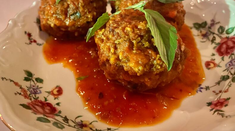 The hint of lemongrass mixed with ground pork sausage takes So So Fed's sai gok meatballs, ladled with mild tomato sauce, into unexpected territory. Ligaya Figueras/ligaya.figueras@ajc.com