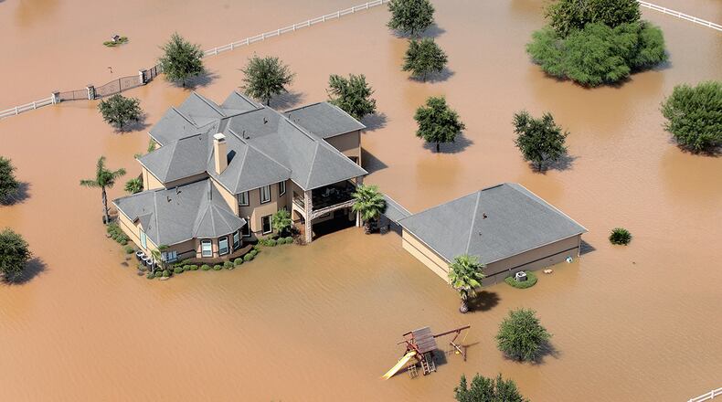 A home is surrounded by floodwater after torrential rains pounded Southeast Texas following Hurricane and Tropical Storm Harvey(Photo by Scott Olson/Getty Images)