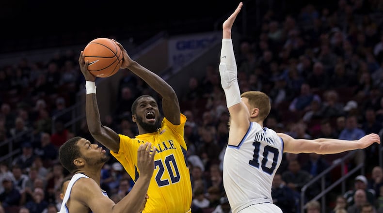 B.J. Johnson #20 of the La Salle Explorers attempts a shot against Omari Spellman #14 and Donte DiVincenzo #10 of the Villanova Wildcats in the second half at the Wells Fargo Center on December 10, 2017 in Philadelphia, Pennsylvania. The Wildcats defeated the Explorers 77-68. (Photo by Mitchell Leff/Getty Images)