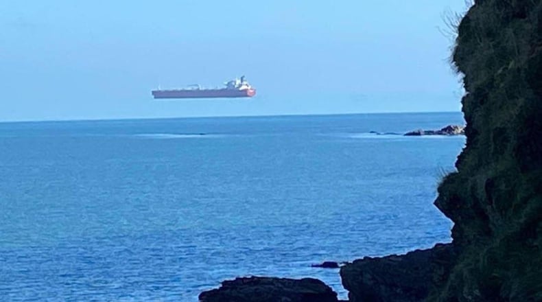 A ship appears to hover over the sea off the coast of Cornwall, England, in a photo captured by David Morris that shows the optical illusion known as "superior mirage," caused by warm air sitting on top of colder air bending light as it reaches a viewer's eyes.